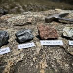 Amostras de minerais críticos como nióbio, grafita, terras raras e níquel sobre superfície rochosa