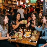 Mulher adulta com copo de bebida alcoólica em ambiente doméstico com expressão de cansaço