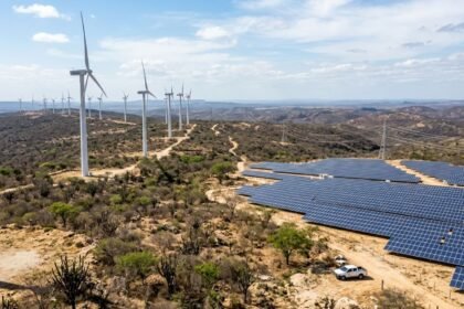 Turbinas eólicas e painéis solares no sertão do Nordeste brasileiro com linhas de transmissão ao fundo