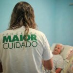 Cuidador profissional fazendo visita domiciliar a idoso em casa