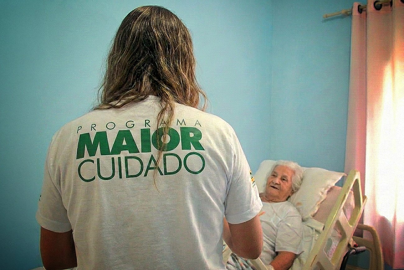 Cuidador profissional fazendo visita domiciliar a idoso em casa