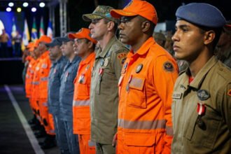 Policial militar e bombeiro em farda durante apresentação de segurança pública nas ruas