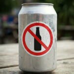 Lata de cerveja ao lado de martelo de juiz representando debate sobre publicidade de bebidas alcoólicas no Brasil